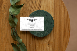 Business Card Mockup on a Wooden Table with Floral Accents psd