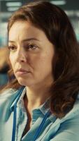Vertical Portrait of sad woman at work dejected by corporate lifestyle, wishing to quit job. Close up of upset employee feeling emotional strain in workplace environment, overwhelmed by tasks, camera B video