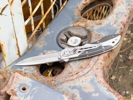 plegable bolsillo cuchillo en oxidado metal superficie al aire libre foto