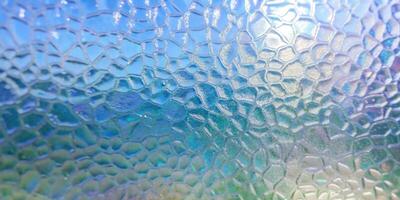 Glass surface resembling the textures of fish scales under light. photo