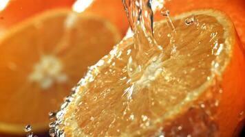 l'eau est versé sur moitié un orange. filmé sur une haute vitesse caméra à 1000 ips. haute qualité Full HD métrage video
