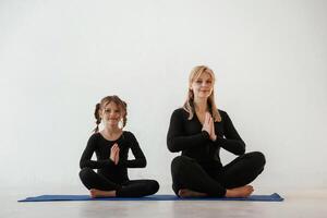 madre, y pequeño ,hija son en aptitud ropa en yoga estera foto