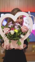 femme souriant sur de soi en portant bouquet de fleurs à Accueil video
